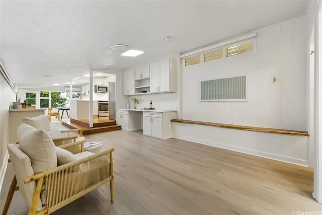 a living room with furniture and kitchen view