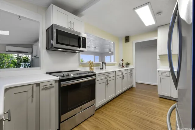 a kitchen with stainless steel appliances a stove a sink and a microwave