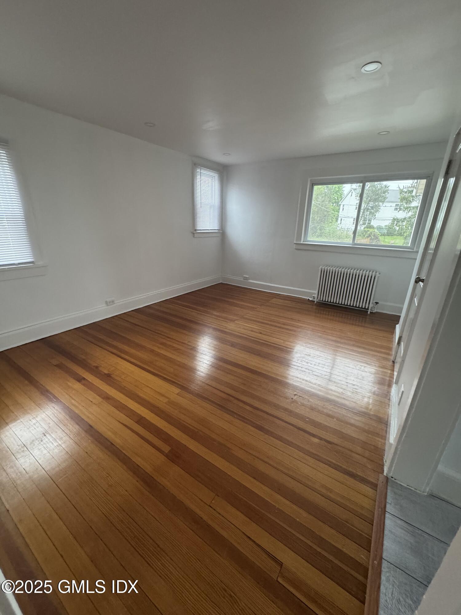 47 Cos Cob Avenue, Unit 3 Cos Cob, CT 06807 - Photo 7 of 12 an empty room with wooden floor and windows