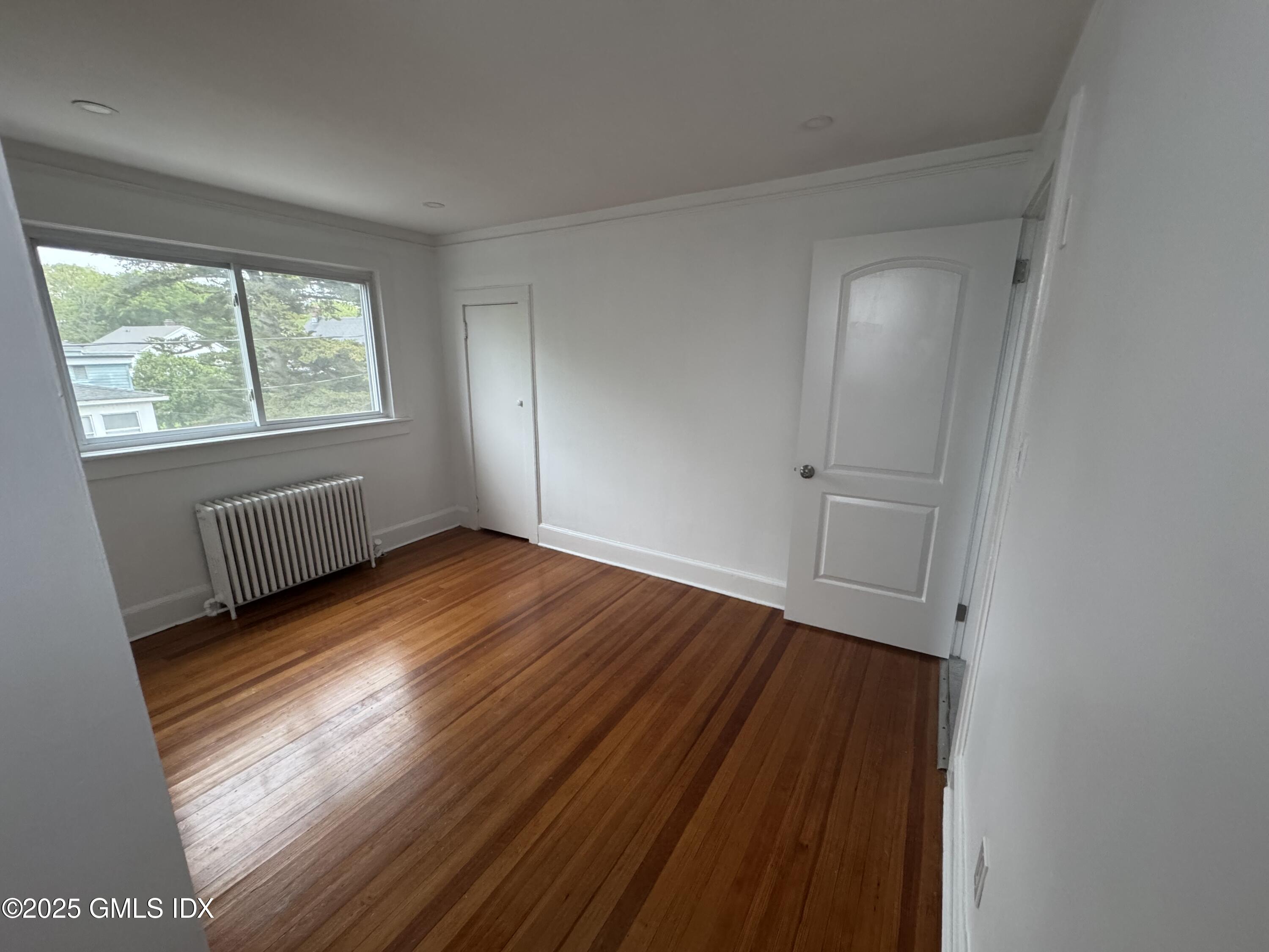 47 Cos Cob Avenue, Unit 3 Cos Cob, CT 06807 - Photo 8 of 12 an empty room with wooden floor and windows