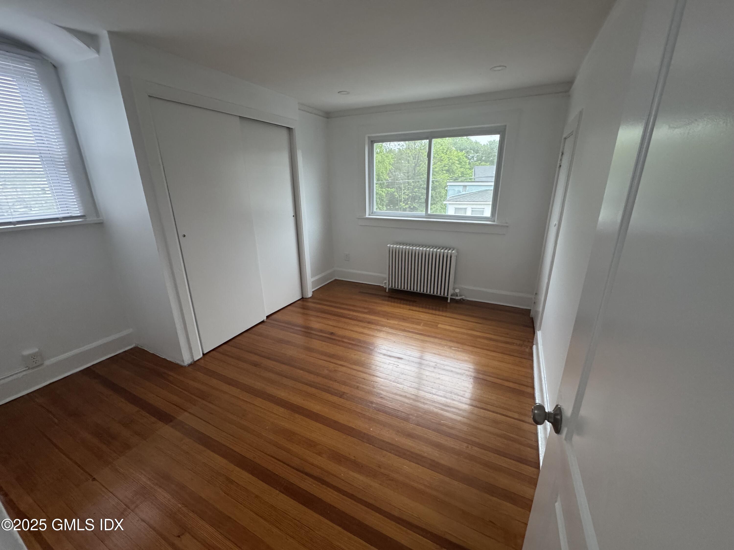 47 Cos Cob Avenue, Unit 3 Cos Cob, CT 06807 - Photo 9 of 12 an empty room with wooden floor and windows