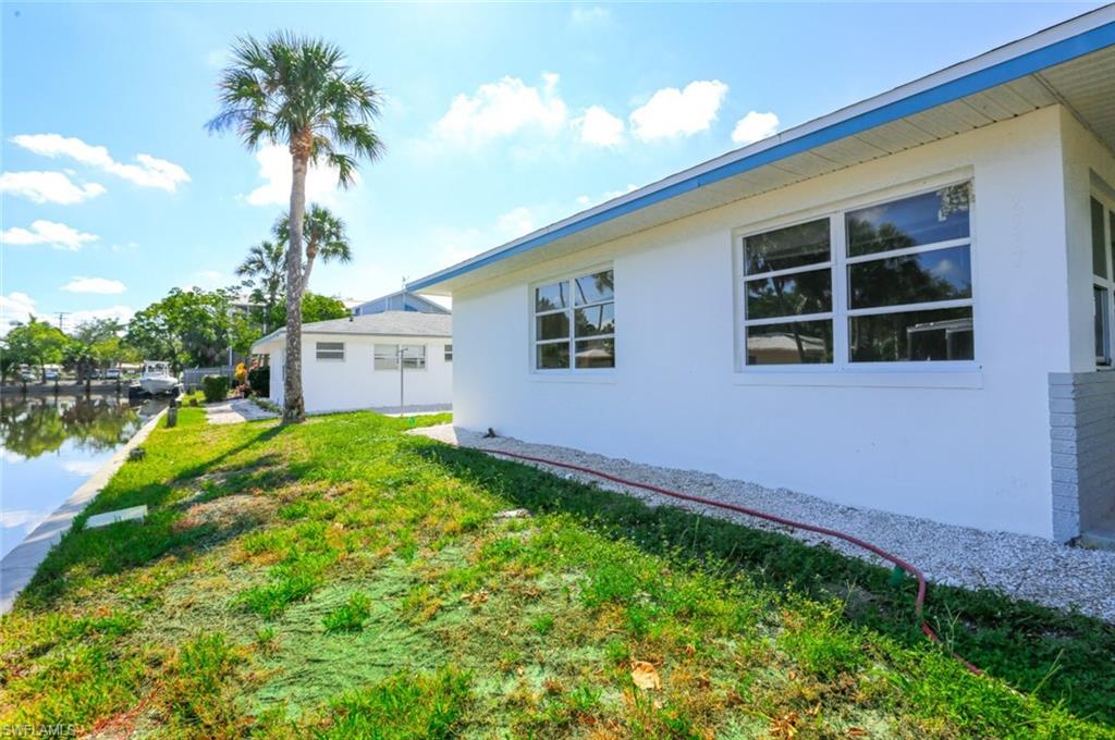 2777 Shoreview Drive, Unit 2 Naples, FL 34112 - Photo 4 of 8 View of side of home featuring a yard and a water view