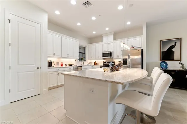 a kitchen with a table chairs refrigerator and cabinets