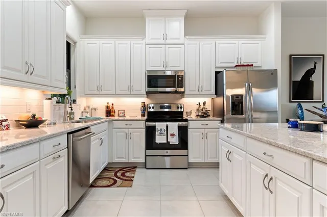 a kitchen with cabinets stainless steel appliances and a sink