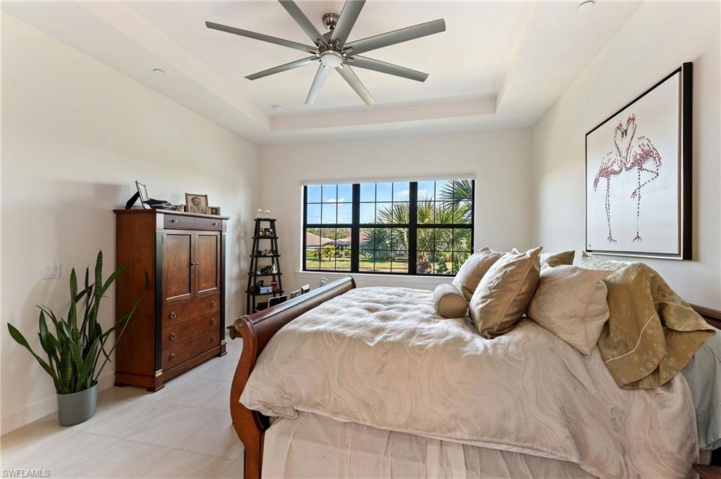 9653 Montelanico Loop, Unit 202 Naples, FL 34119 - Photo 16 of 45 a bedroom with a large bed and a window