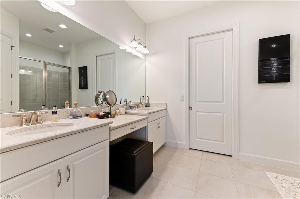 9653 Montelanico Loop, Unit 202 Naples, FL 34119 - Photo 17 of 45 a bathroom with double sink and a mirror