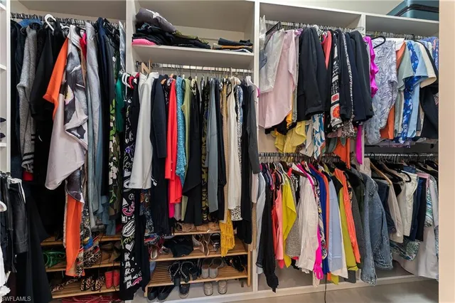 a view of walk in closet with clothes