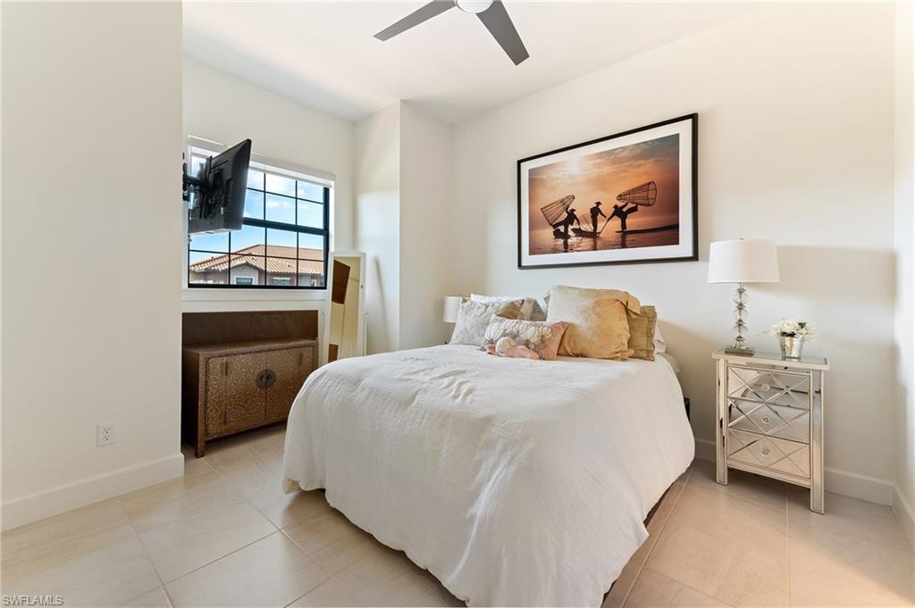 9653 Montelanico Loop, Unit 202 Naples, FL 34119 - Photo 20 of 45 a bedroom with a bed and a chandelier