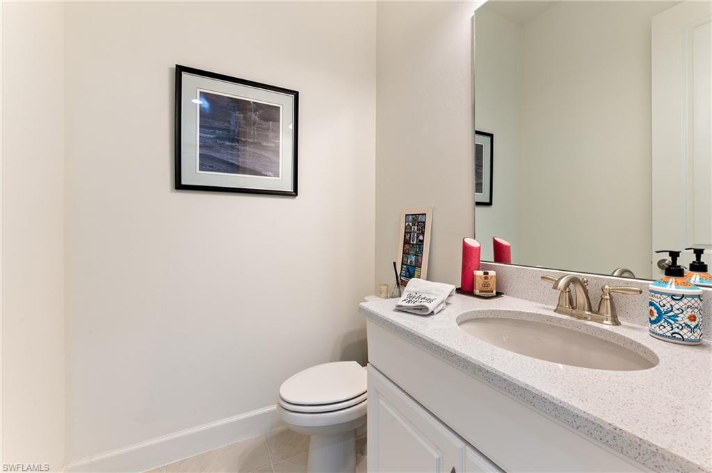 9653 Montelanico Loop, Unit 202 Naples, FL 34119 - Photo 23 of 45 a bathroom with a sink vanity mirror and toilet
