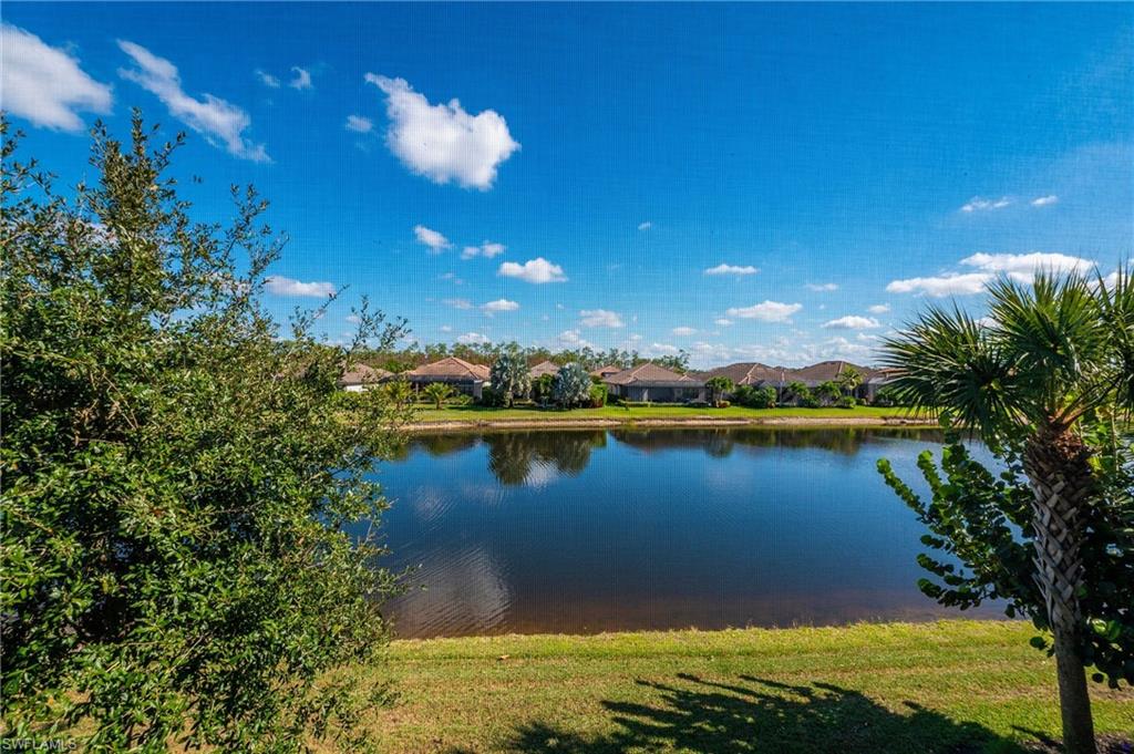 9653 Montelanico Loop, Unit 202 Naples, FL 34119 - Photo 27 of 45 a view of a lake and a yard