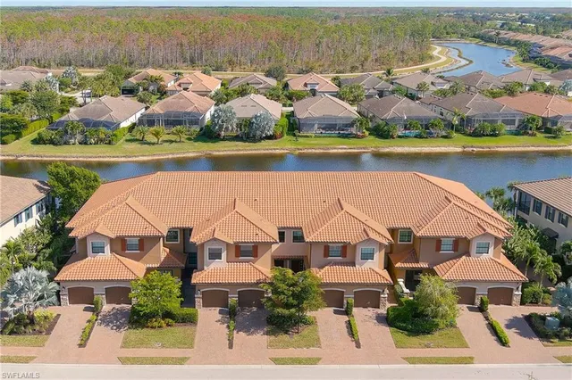 an aerial view of residential houses with outdoor space and lake view