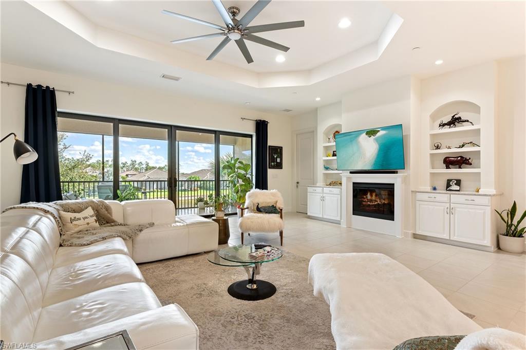 9653 Montelanico Loop, Unit 202 Naples, FL 34119 - Photo 5 of 45 a living room with furniture a fireplace and a flat screen tv