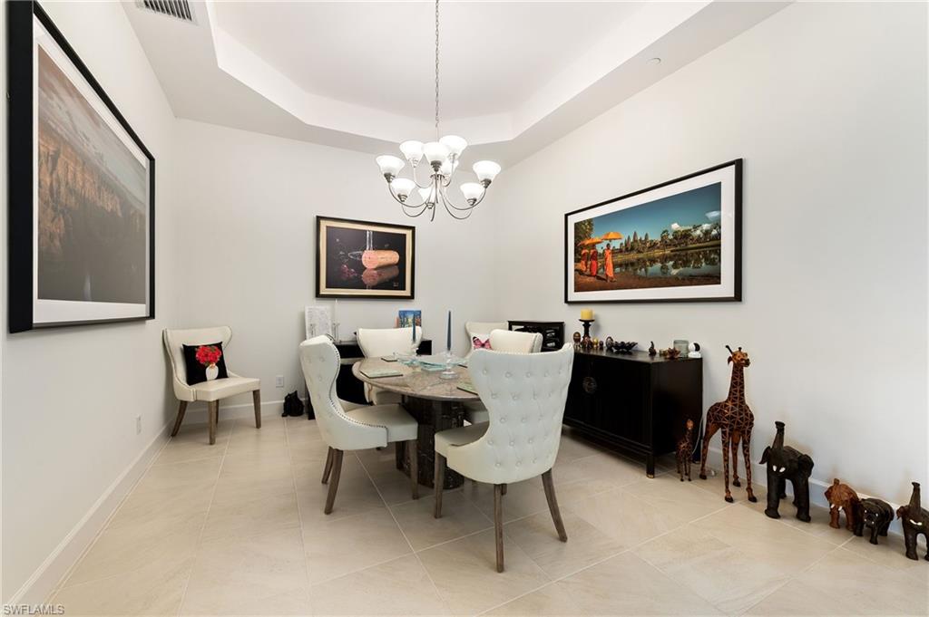 9653 Montelanico Loop, Unit 202 Naples, FL 34119 - Photo 10 of 45 a living room with furniture a chandelier and a flat screen tv