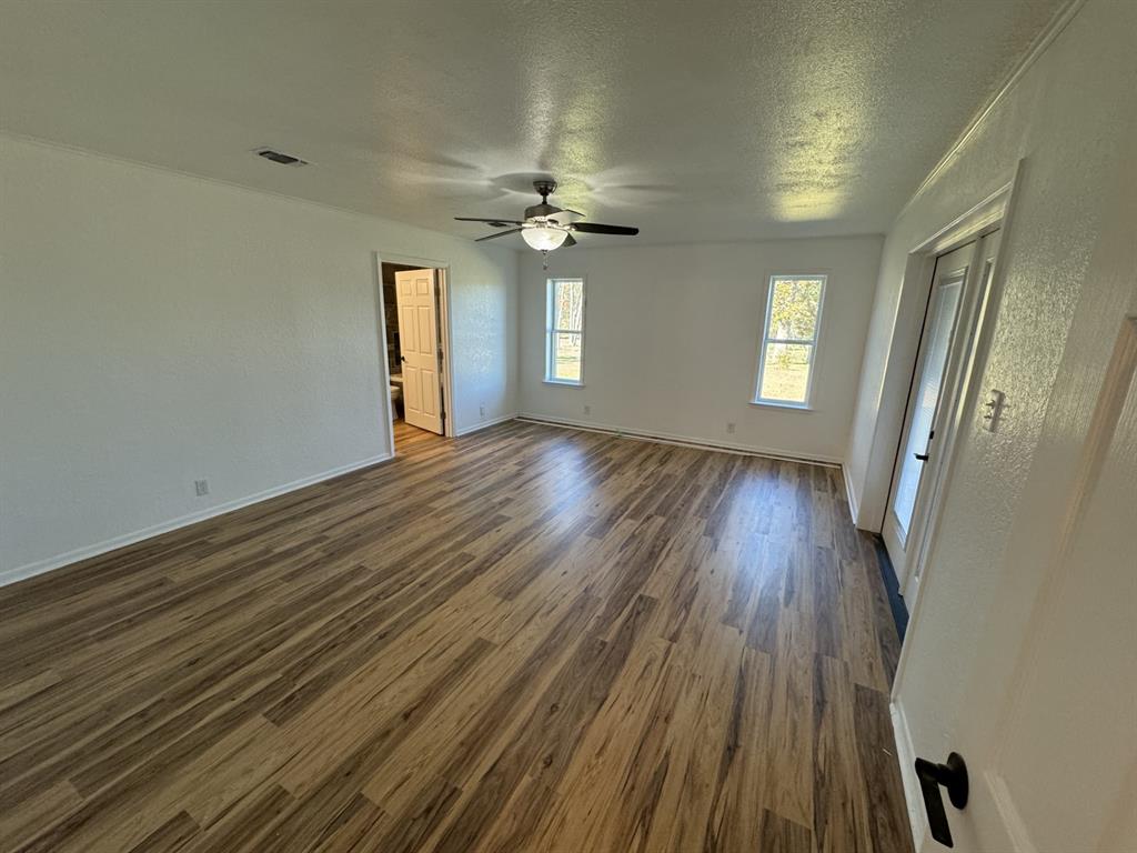 520 County Road Powderly, TX 75473 - Photo 21 of 24 Spare room featuring a textured ceiling, ceiling fan, and dark wood-type flooring