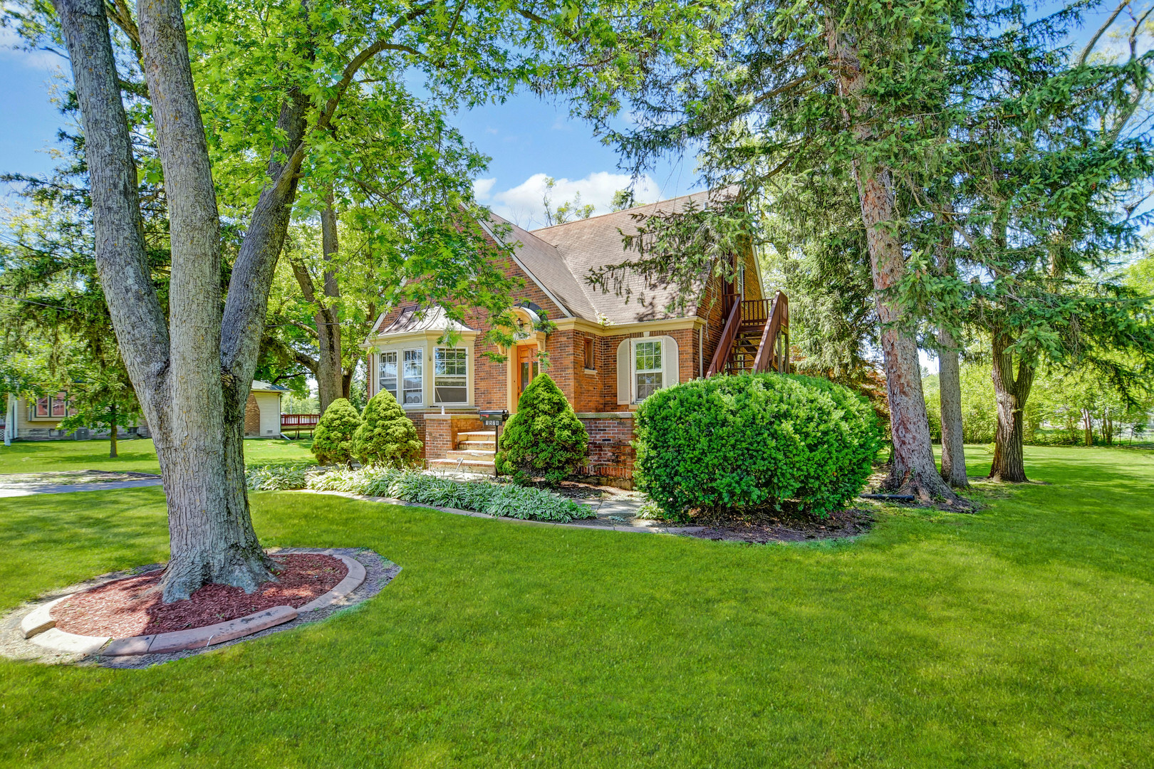 1578 Main Street Crete, IL 60417 - Photo 2 of 38 a view of a garden with a tree in front of the house