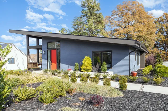 a view of a house with large windows and covered with wooden fence