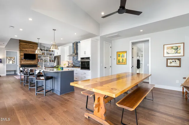 a living room with stainless steel appliances kitchen island a table and chairs in it