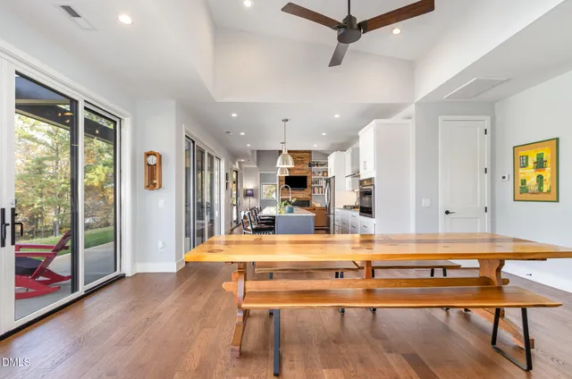 a living room with kitchen view and wooden floor