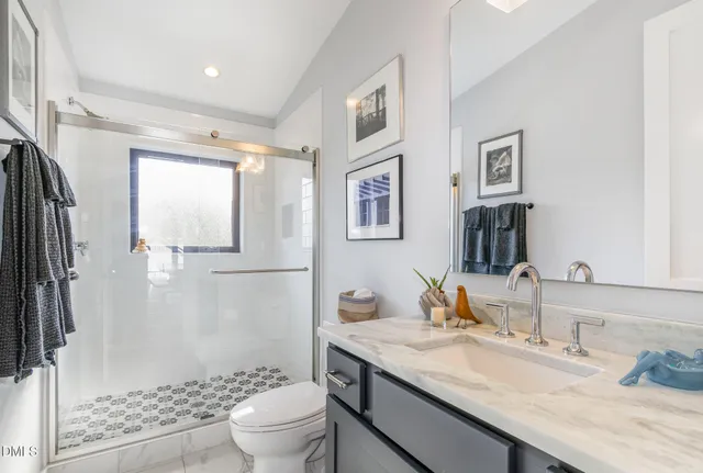 a bathroom with a granite countertop sink toilet and shower