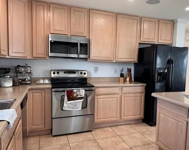 a kitchen with stainless steel appliances granite countertop a refrigerator stove and sink
