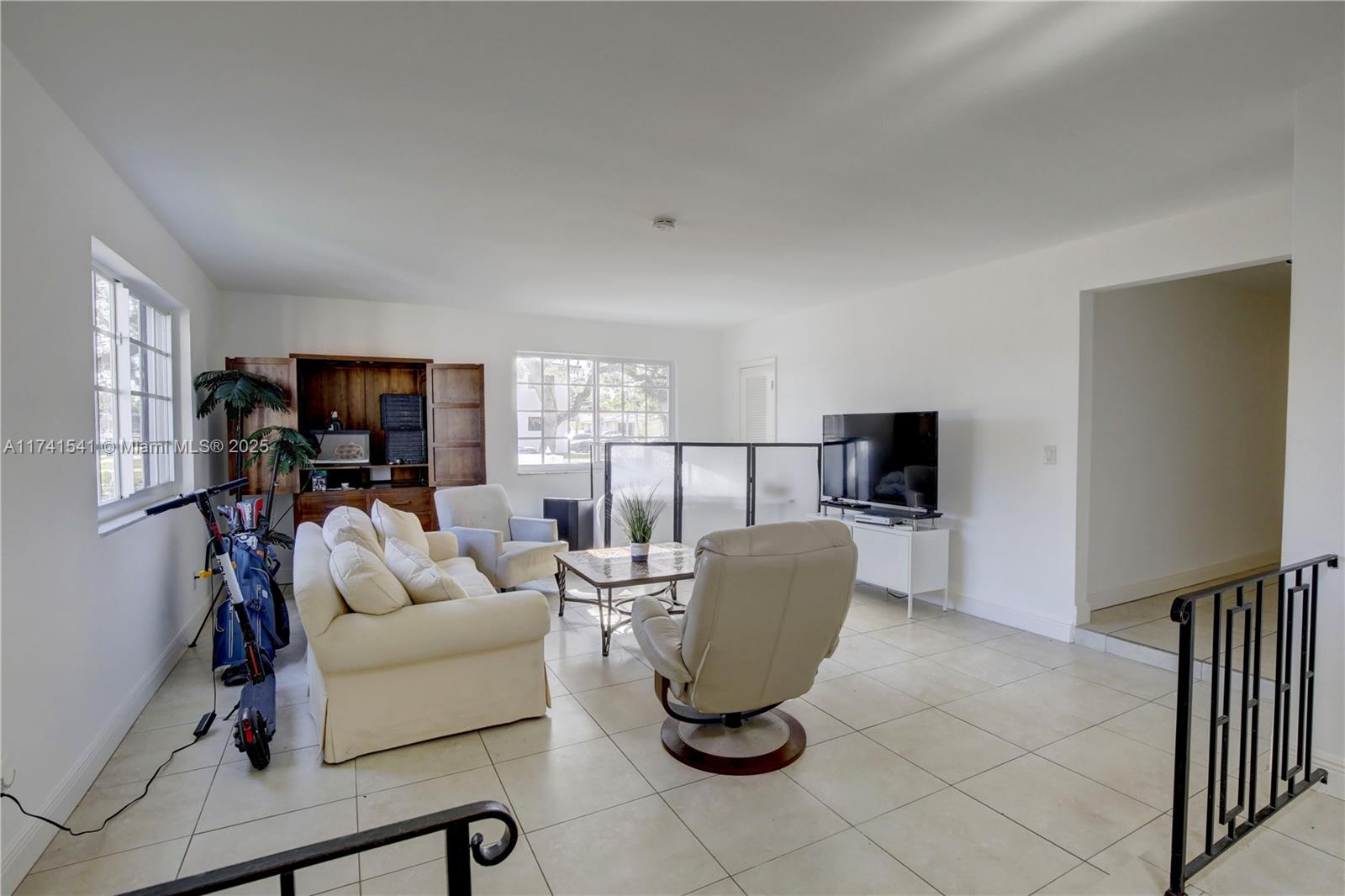 4995 Ponce De Leon Coral Gables, FL 33146 - Photo 14 of 92 a living room with furniture a flat screen tv and a refrigerator