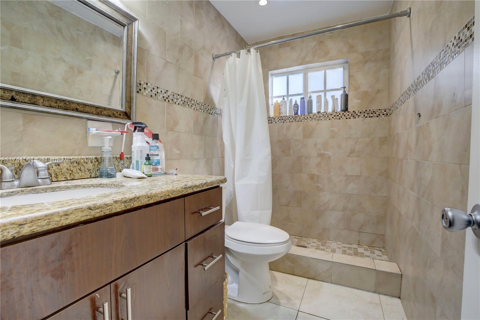 4995 Ponce De Leon Coral Gables, FL 33146 - Photo 23 of 92 a bathroom with a granite countertop sink a toilet a mirror and shower