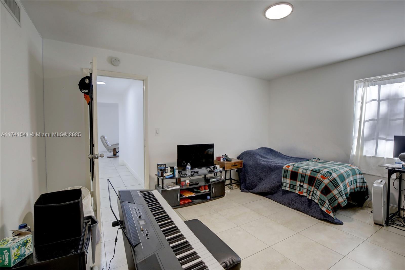 4995 Ponce De Leon Coral Gables, FL 33146 - Photo 26 of 92 a bedroom with a bed and a chandelier