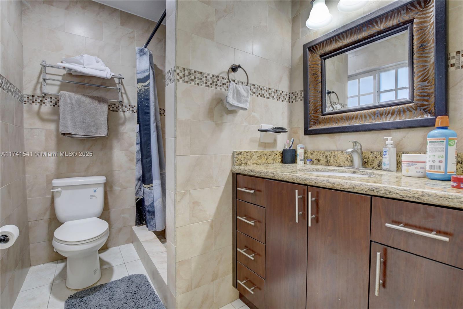 4995 Ponce De Leon Coral Gables, FL 33146 - Photo 31 of 92 a bathroom with a granite countertop sink toilet and shower