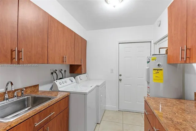 a kitchen with stainless steel appliances a sink dishwasher a refrigerator and cabinets