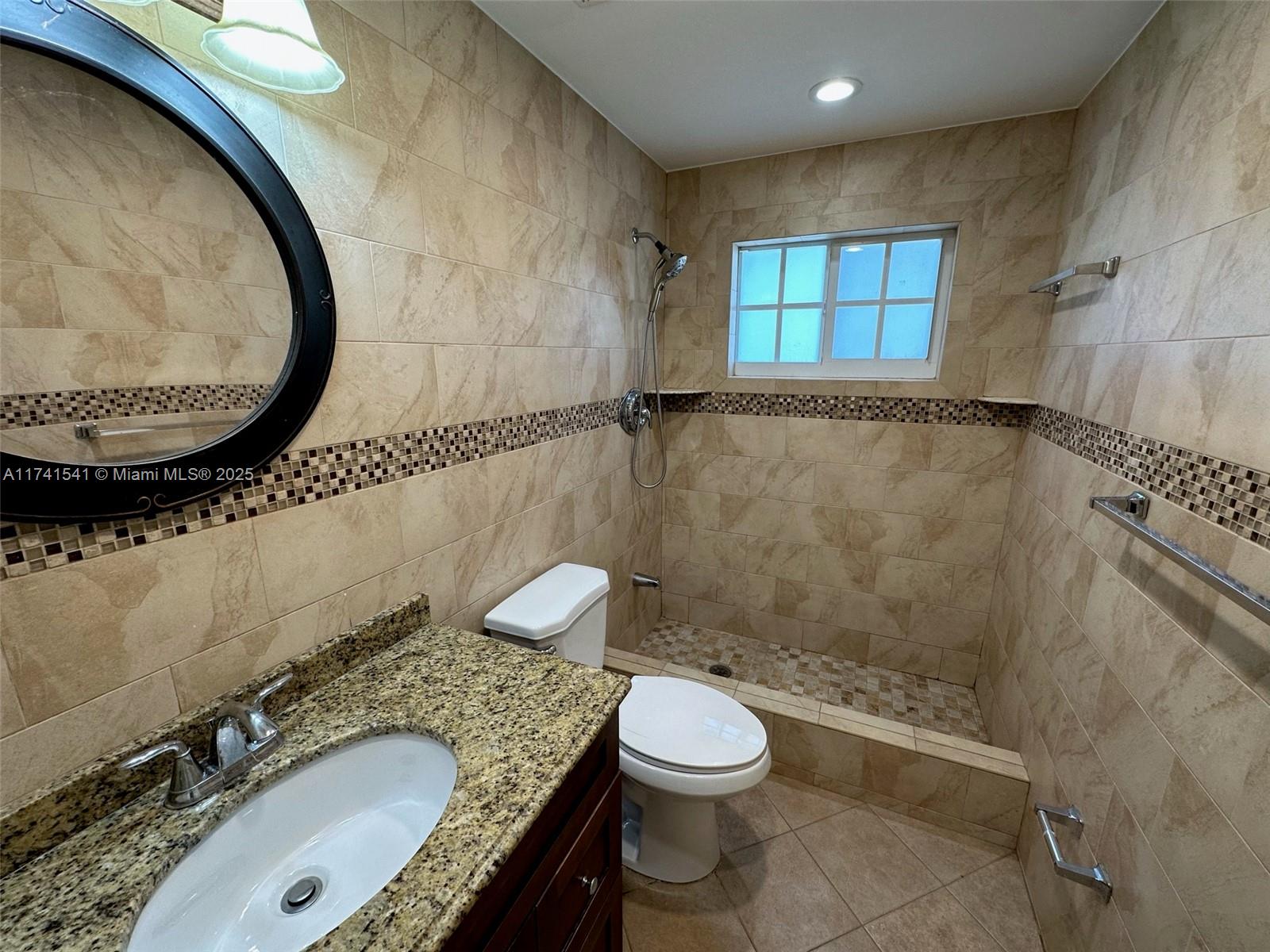 4995 Ponce De Leon Coral Gables, FL 33146 - Photo 58 of 92 a bathroom with a granite countertop sink a mirror and a toilet