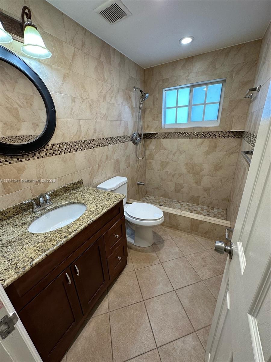 4995 Ponce De Leon Coral Gables, FL 33146 - Photo 63 of 92 a bathroom with a granite countertop sink a toilet and a mirror