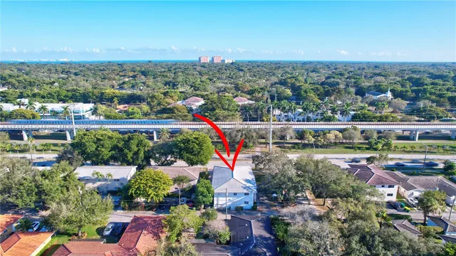 a living room with furniture a flat screen tv and a refrigerator
