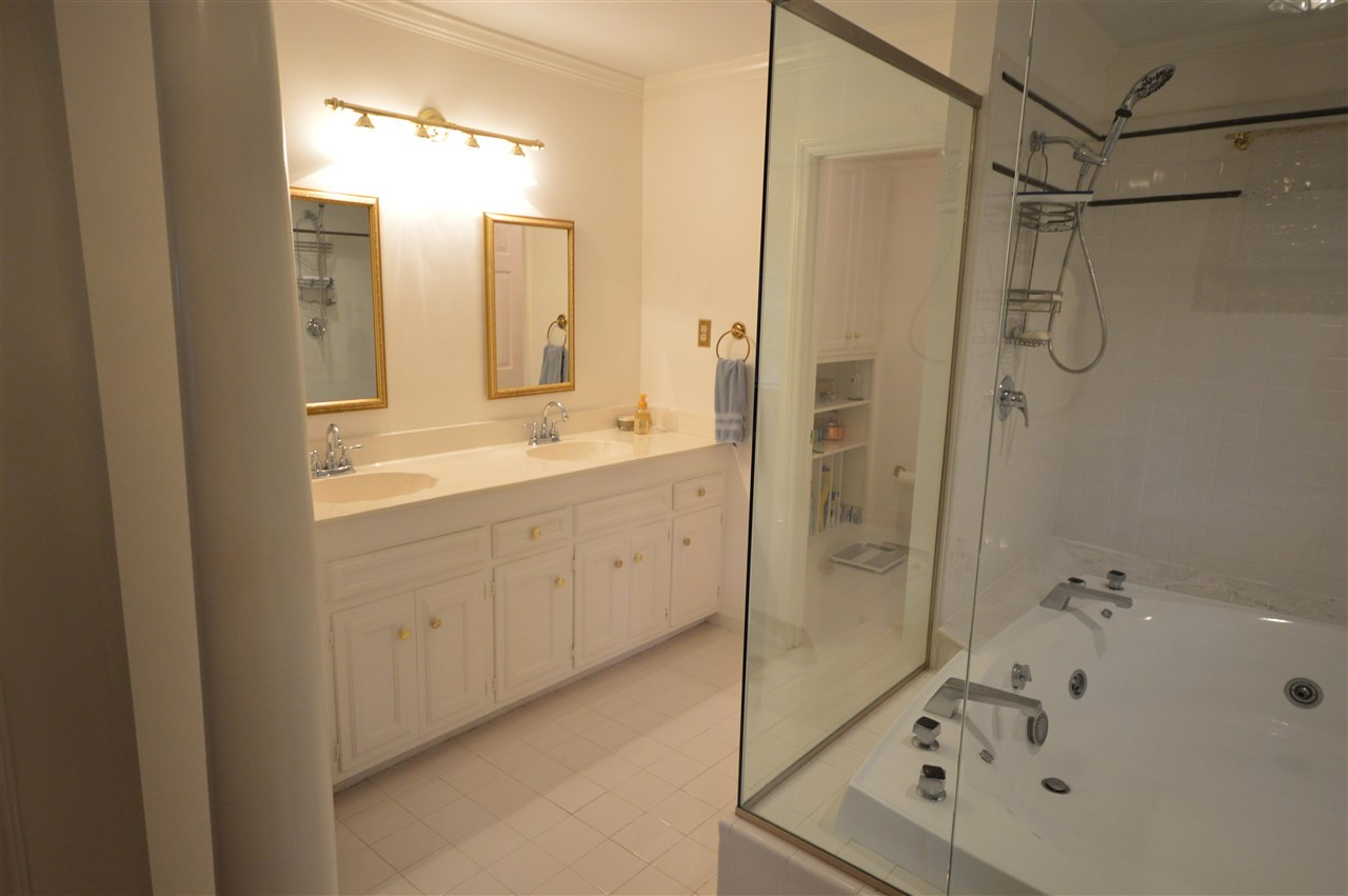 2929 Buckingham Road Durham, NC 27707 - Photo 17 of 26 a bathroom with a shower sink and mirror