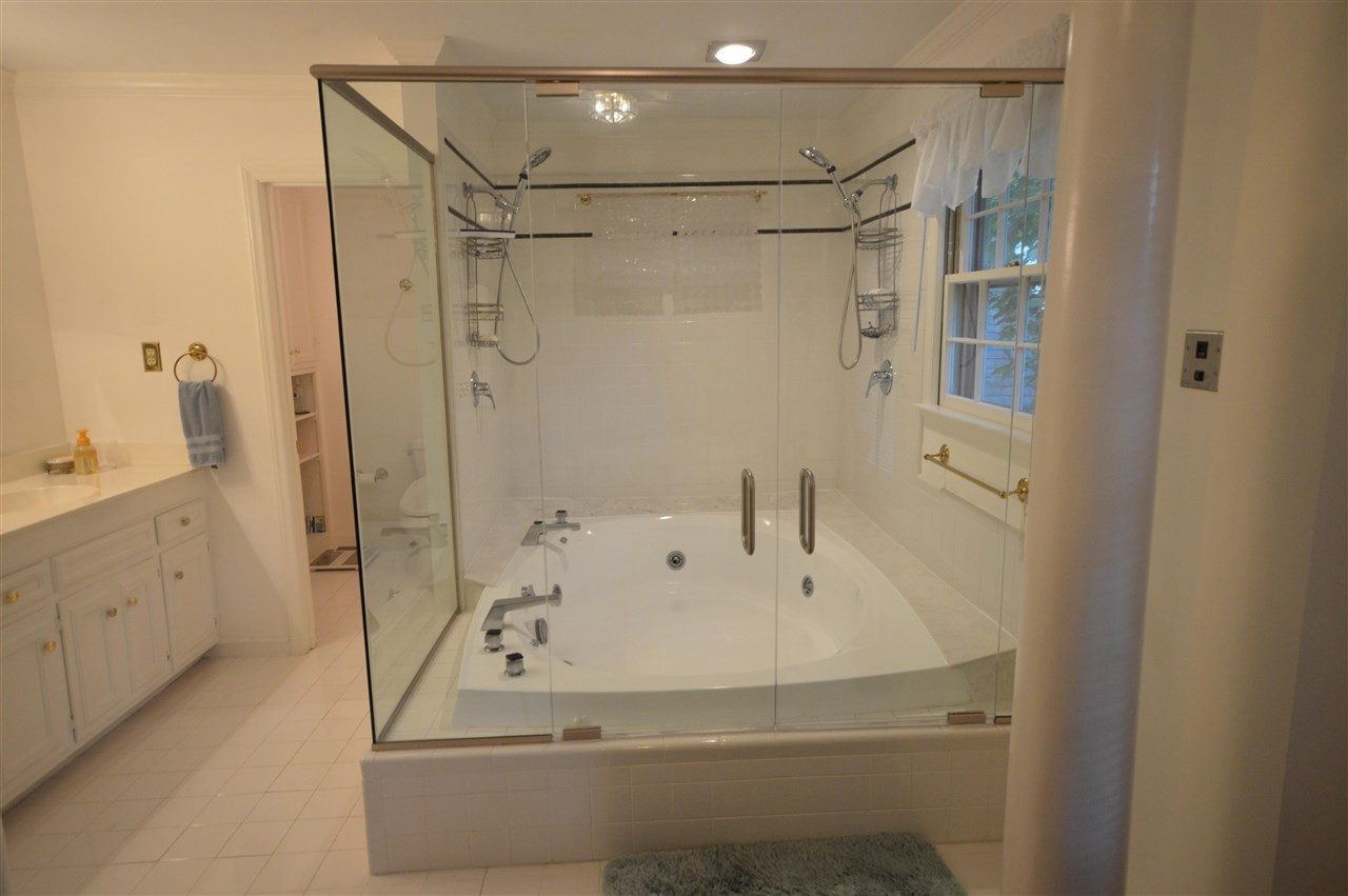 2929 Buckingham Road Durham, NC 27707 - Photo 19 of 26 a bathroom with a white tub shower vanity and a sink