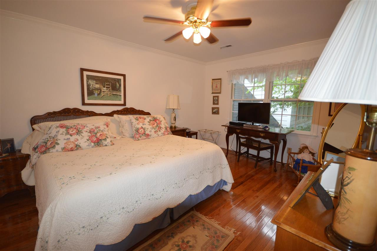 2929 Buckingham Road Durham, NC 27707 - Photo 20 of 26 a bedroom with a bed and a chandelier