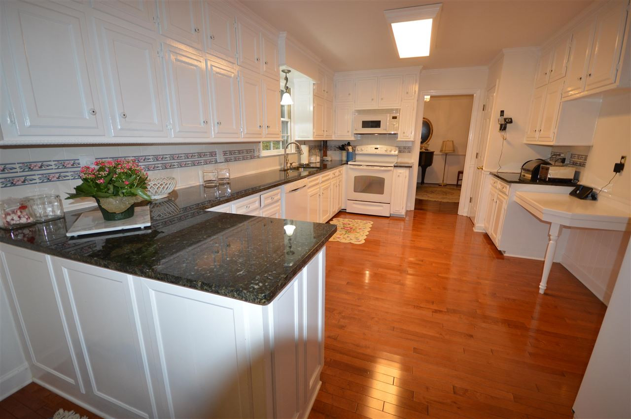 2929 Buckingham Road Durham, NC 27707 - Photo 10 of 26 a kitchen with stainless steel appliances granite countertop a sink a stove top oven a counter space and cabinets