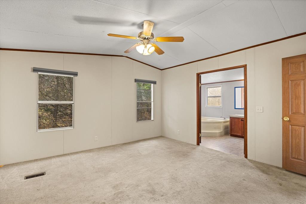 2903 Centaurus Way Granbury, TX 76048 - Photo 22 of 31 Unfurnished bedroom featuring ornamental molding, ceiling fan, lofted ceiling, light colored carpet, and ensuite bath