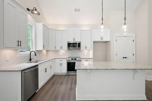 a kitchen with stainless steel appliances granite countertop a sink stove and cabinets