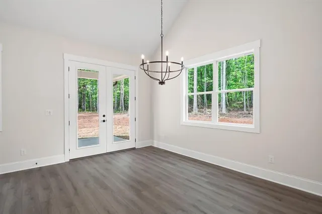 a view of an empty room with wooden floor fireplace and a window