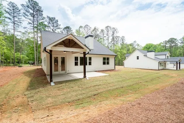 an aerial view of residential houses with outdoor space and trees