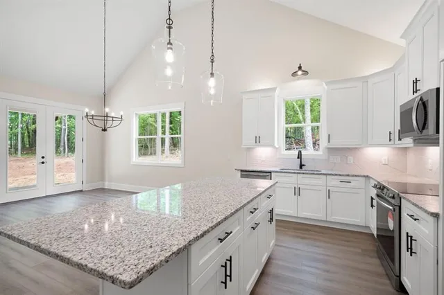 a kitchen with kitchen island white cabinets and wooden floor