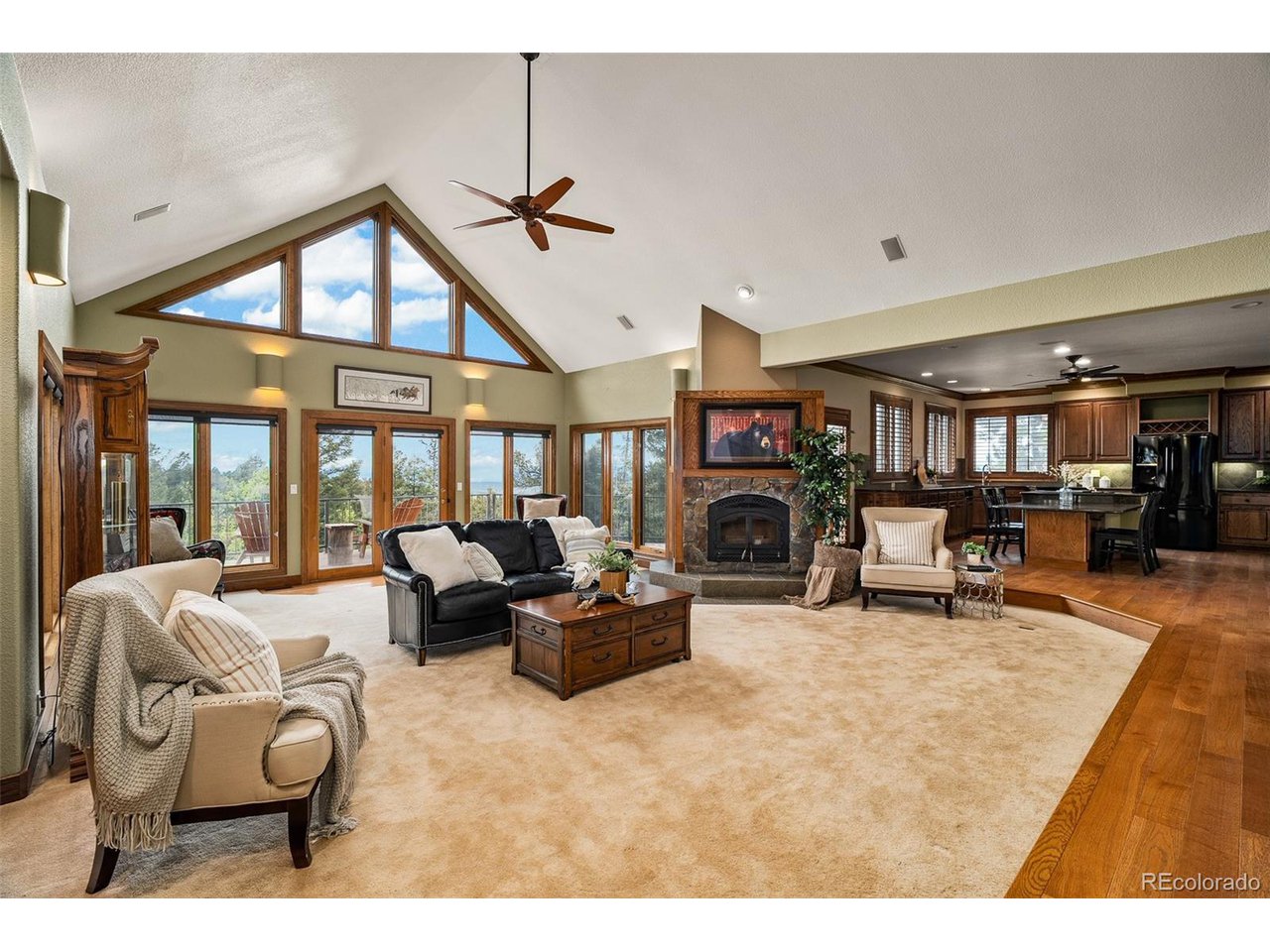 2755 Elk Ridge Divide Divide, CO 80814 - Photo 13 of 50 Living room with soaring vaulted ceilings, wood-burning fireplace, and an open concept with main-level access to the dining room, kitchen, primary suite, and walkout to the new rear composite deck with stunning views of the Front Range