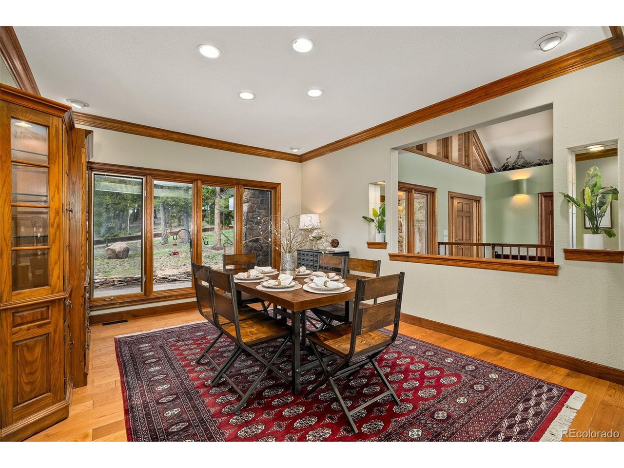 2755 Elk Ridge Divide Divide, CO 80814 - Photo 18 of 50 Separate dining room swathed in natural sunlight, adorned with architectural molding, hardwood floors, and walkout to the new rear composite deck with gorgeous views of the Front Range