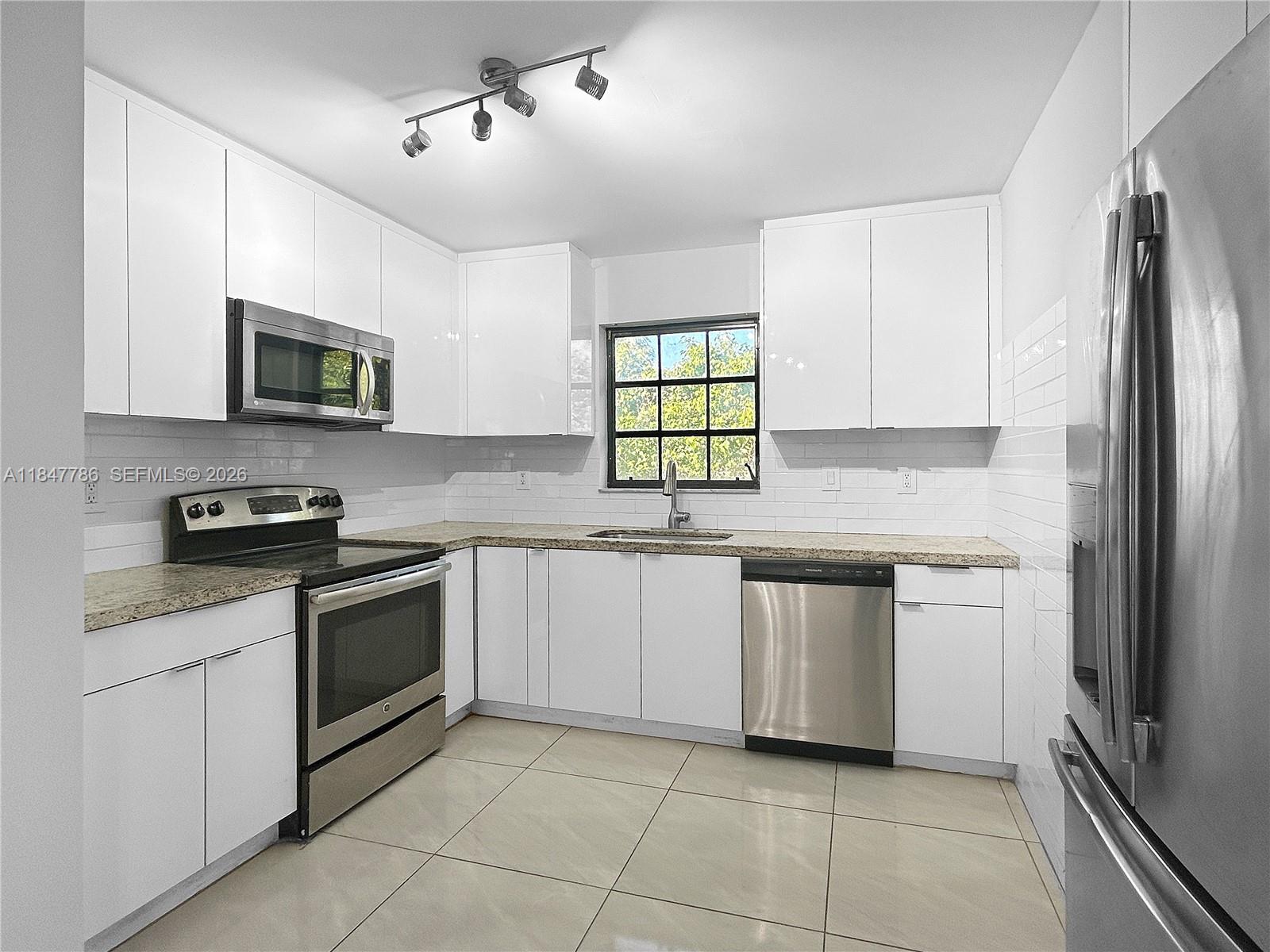 13925 Southwest 26th Terrace Miami, FL 33175 - Photo 13 of 42 a kitchen with stainless steel appliances granite countertop a stove a sink and a refrigerator