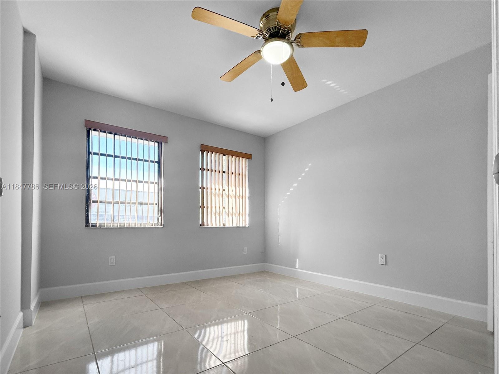 13925 Southwest 26th Terrace Miami, FL 33175 - Photo 28 of 42 an empty room with windows and fan