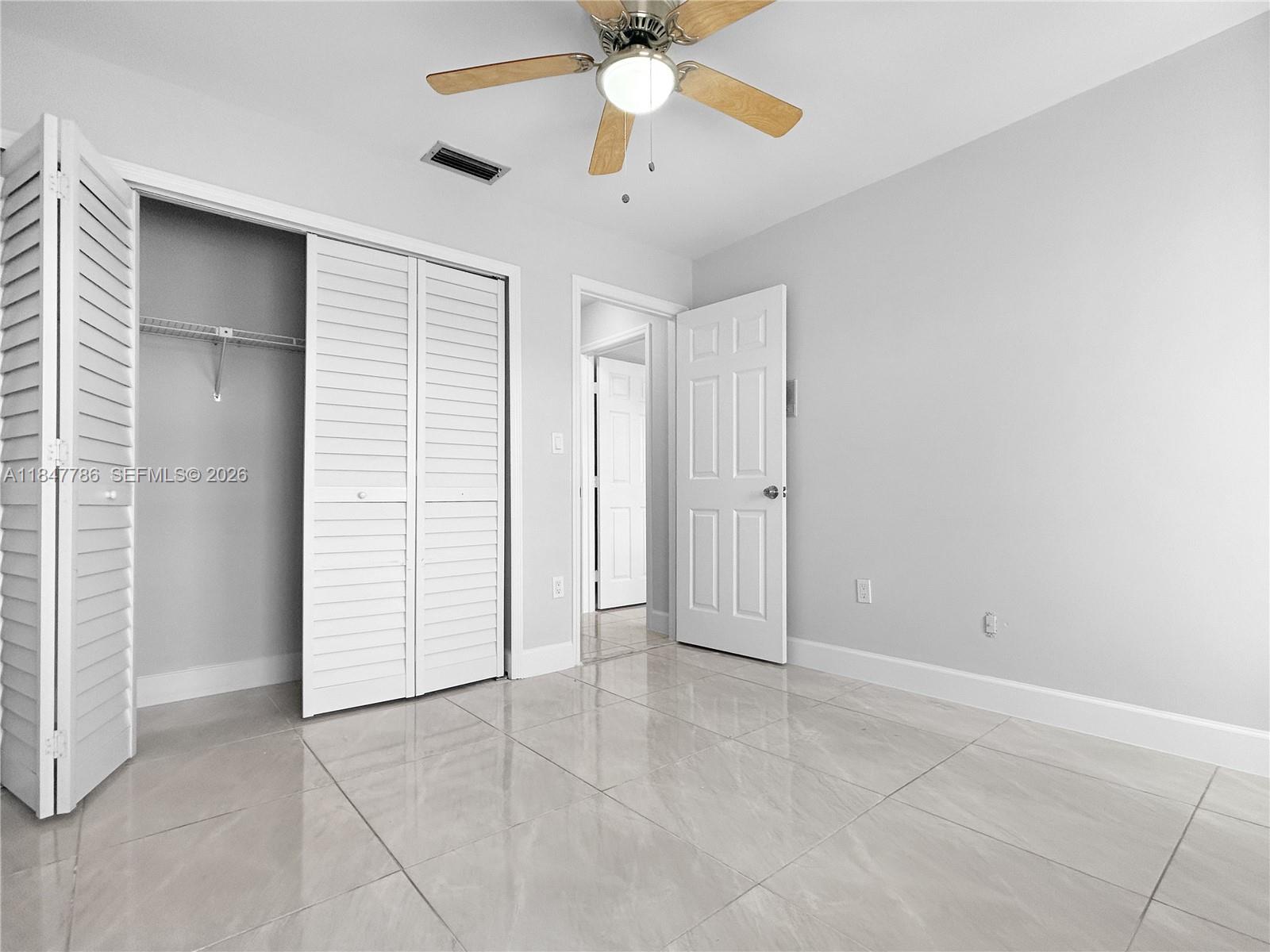 13925 Southwest 26th Terrace Miami, FL 33175 - Photo 30 of 42 an empty room with closet and a ceiling fan