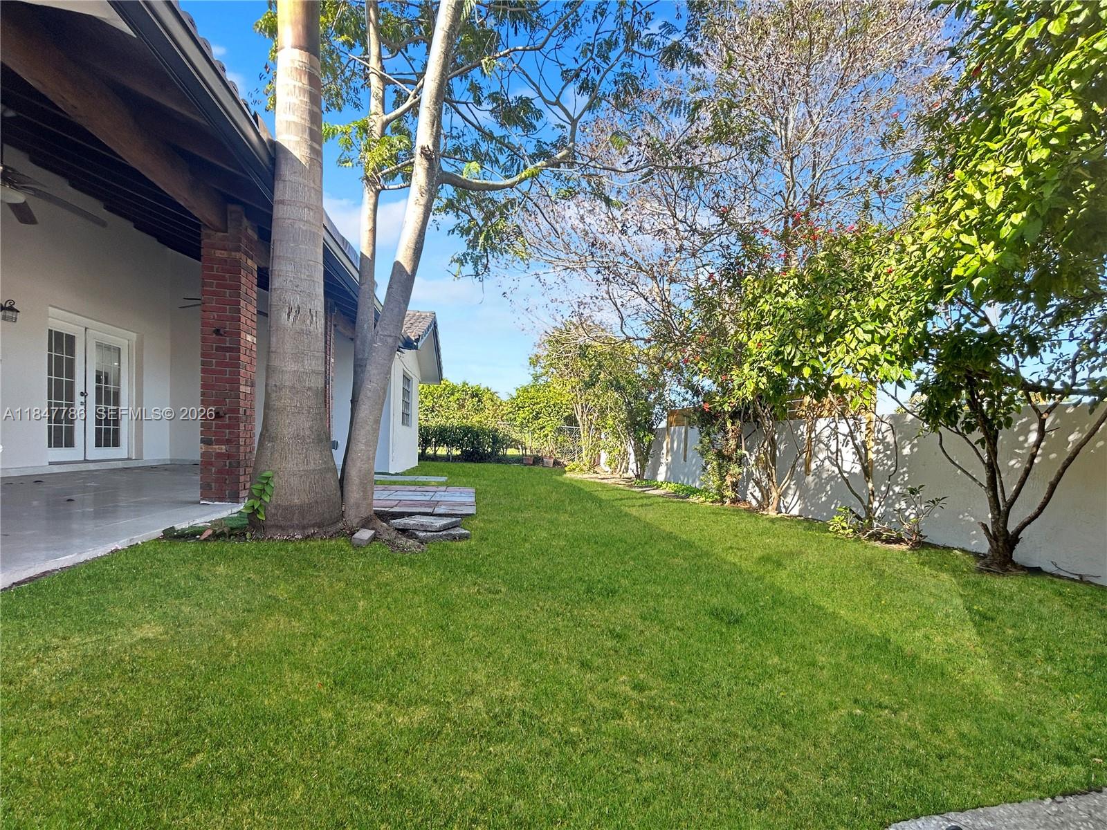 13925 Southwest 26th Terrace Miami, FL 33175 - Photo 40 of 42 a backyard of a house with plants and large tree