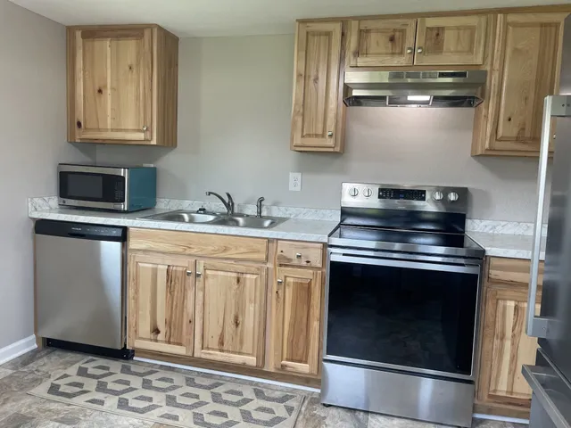 a kitchen with stainless steel appliances granite countertop a stove and a microwave