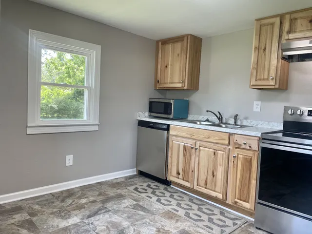 a kitchen with stainless steel appliances granite countertop a sink stove and microwave
