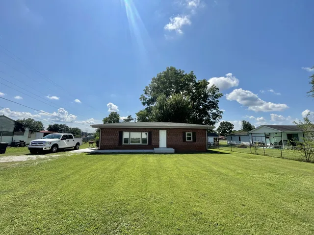a view of a house with a big yard and sitting area